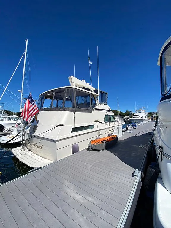 Slide: The Image of 1991 Hatteras 40 Motor Yacht docked at a marina on a sunny day. - 14