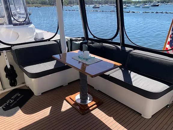 Slide: The Image of 1991 Hatteras 40 Motor Yacht interior with seating and table, overlooking marina. - 16