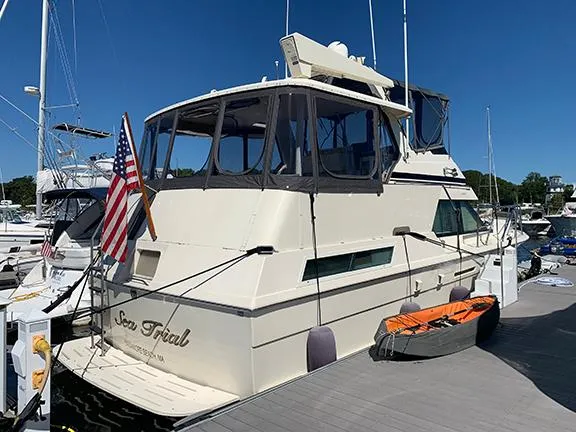 Slide: The Image of 1991 Hatteras 40 Motor Yacht docked with American flag and kayak. - 2