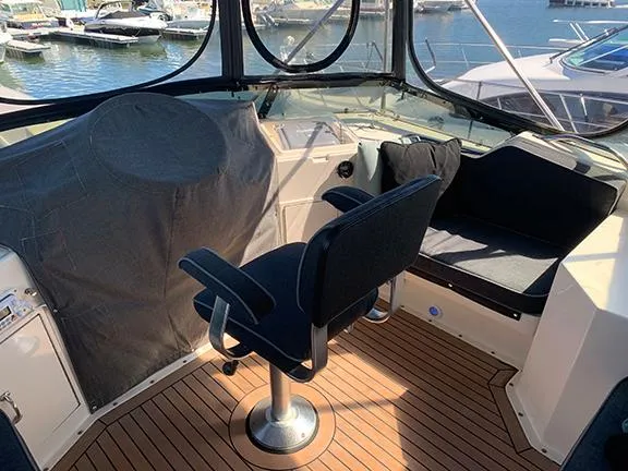 Slide: The Image of 1991 Hatteras 40 Motor Yacht helm with seating and marina view. - 22