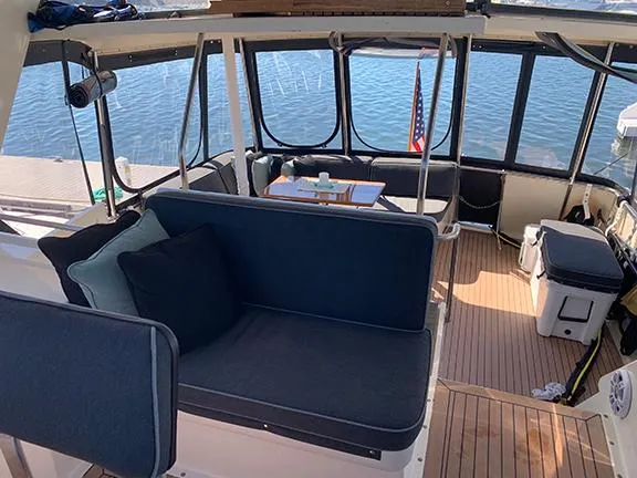 Slide: The Image of 1991 Hatteras 40 Motor Yacht interior with seating and table, docked by the water. - 23