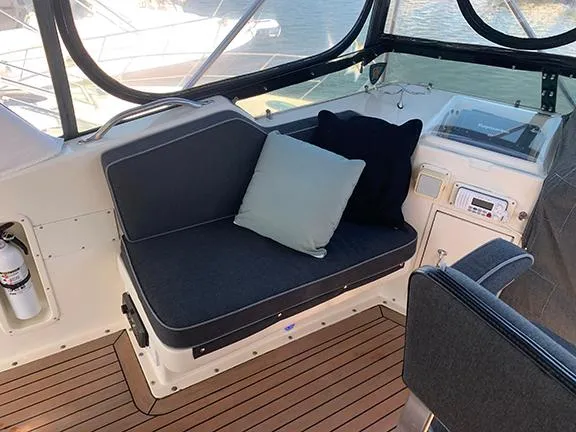 Slide: The Image of Interior seating area of 1991 Hatteras 40 Motor Yacht with cushions and wooden flooring. - 24