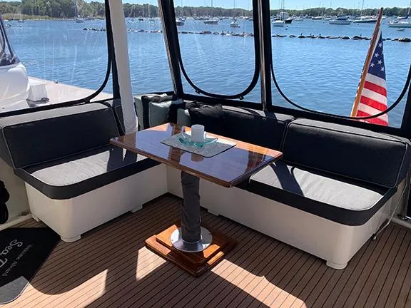 Slide: The Image of 1991 Hatteras 40 Motor Yacht interior with seating and table, overlooking marina. - 44