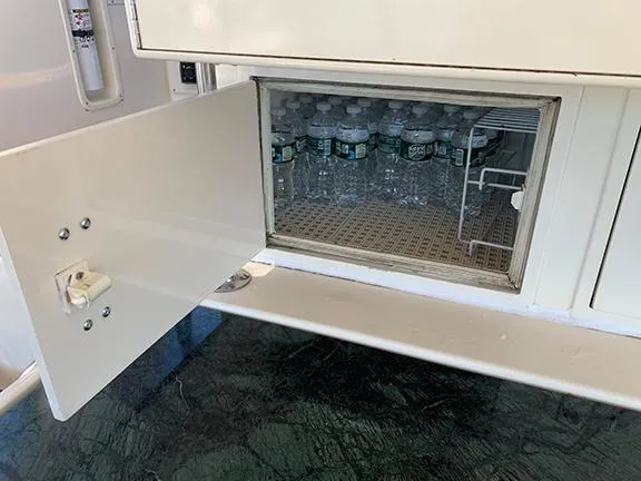 Slide: The Image of Small refrigerator with bottled water on a 1991 Hatteras 40 Motor Yacht. - 46