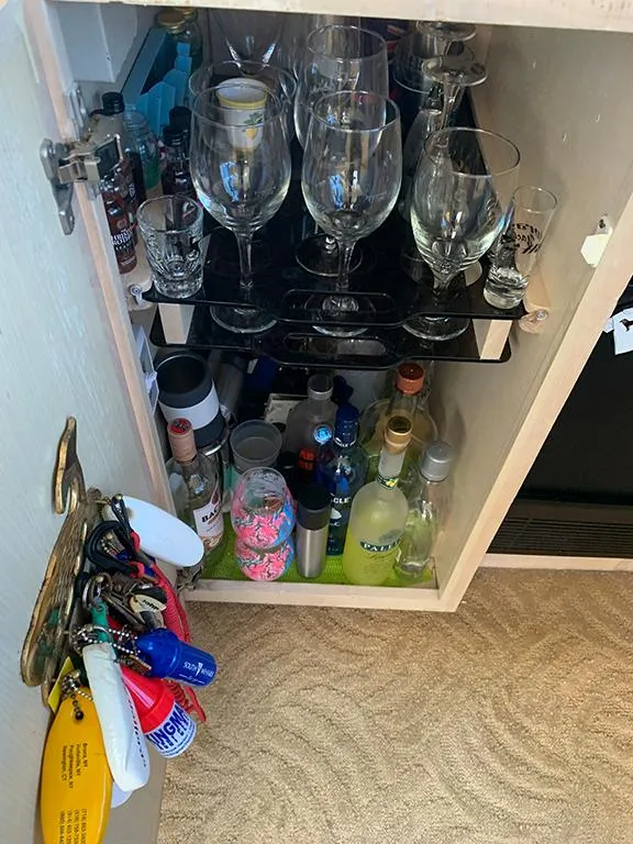 Slide: The Image of 1991 Hatteras 40 Motor Yacht bar cabinet with glassware and assorted bottles. - 49