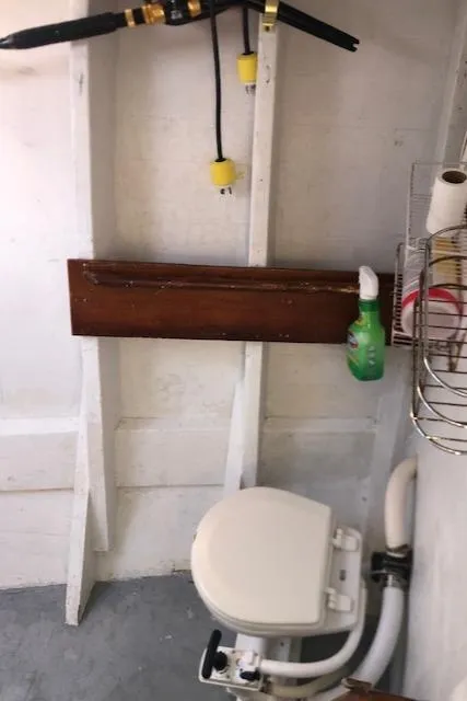 Slide: The Image of 1979 Custom Carolina Sportfish 35 boat bathroom with toilet and cleaning supplies. - 9