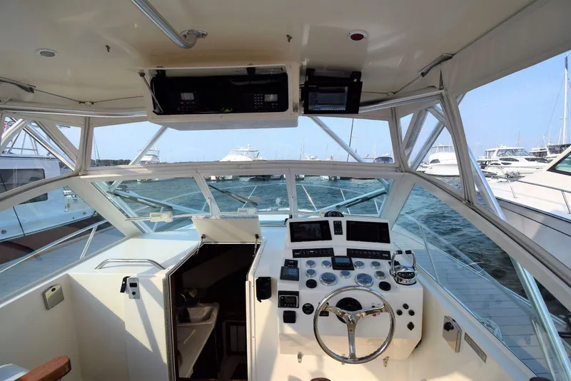 Slide: The Image of 2007 Carolina Classic 28 Express boat cockpit with steering wheel and control panel, docked at marina. - 11