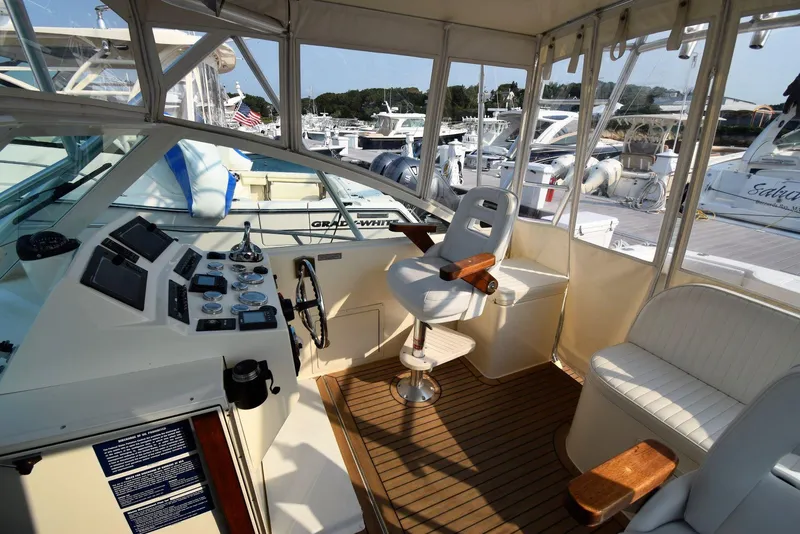 Slide: The Image of 2007 Carolina Classic 28 Express boat interior with helm, seating, and marina view. - 15