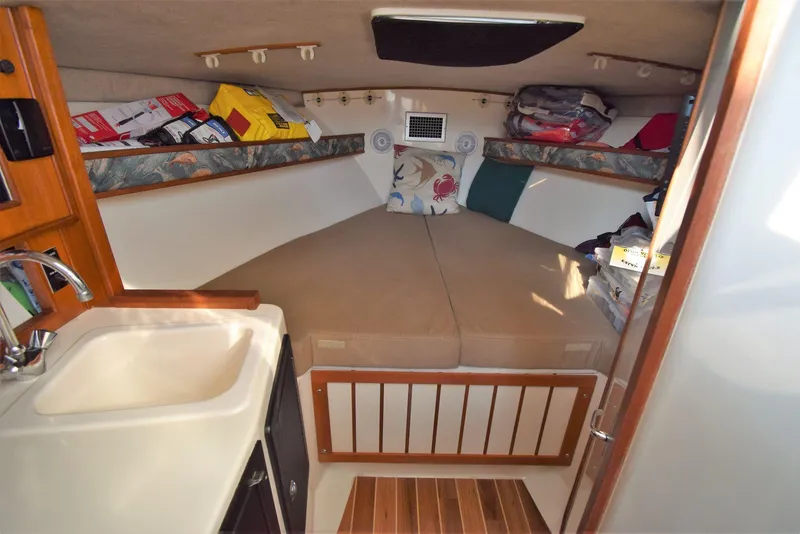 Slide: The Image of 2007 Carolina Classic 28 Express cabin interior with cozy bed and compact sink area. - 16