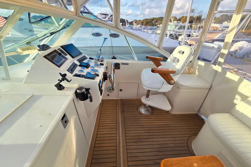 Slide: The Image of 2007 Carolina Classic 28 Express boat cockpit with helm, controls, and seating on teak flooring. - 22