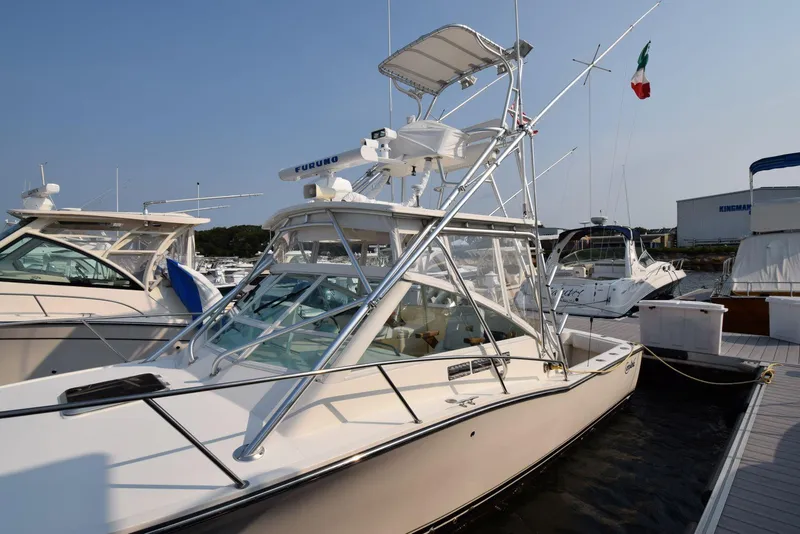 Slide: The Image of 2007 Carolina Classic 28 Express boat docked at marina, featuring sleek design and fishing equipment. - 5