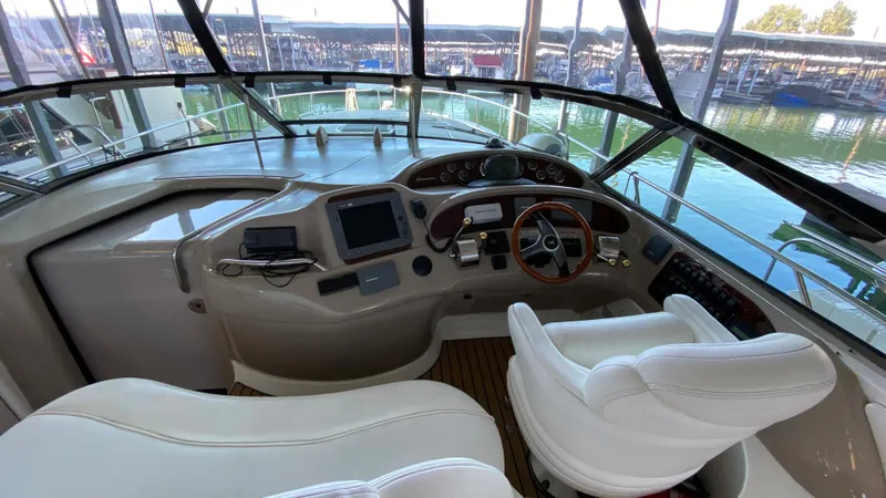 Slide: The Image of Helm of 2001 Sea Ray 460 Sundancer yacht with modern controls and white seating. - 11