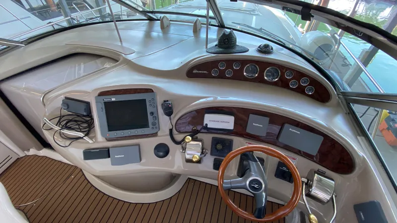 Slide: The Image of 2001 Sea Ray 460 Sundancer helm with navigation equipment and wooden steering wheel. - 13