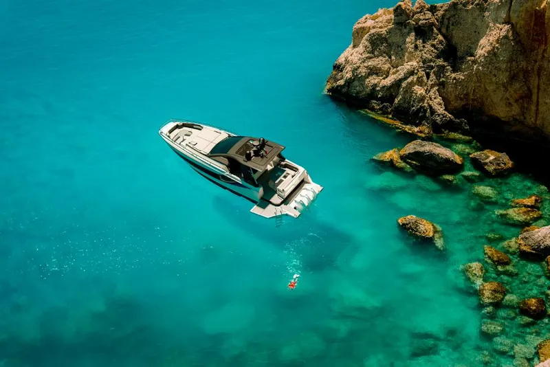 Slide: The Image of 2023 Azimut Verve 42 yacht anchored in clear turquoise waters near rocky cliffs. - 4