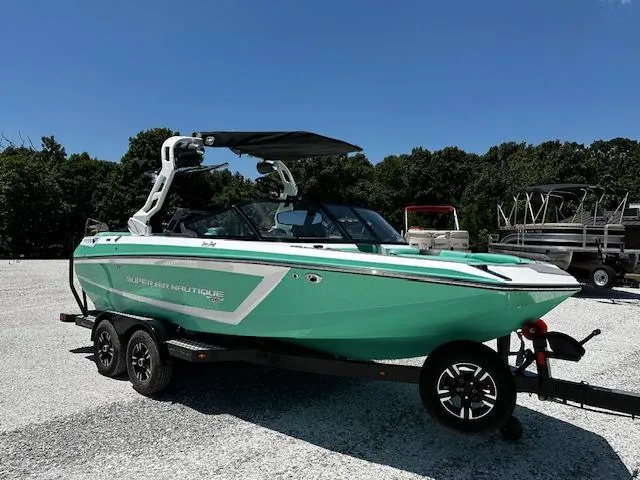 Slide: The Image of 2021 Nautique GS20 boat on a trailer in a parking lot. - 0