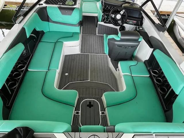 Slide: The Image of 2021 Nautique GS20 boat interior with teal and gray seating. - 16