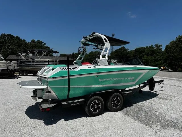 Slide: The Image of 2021 Nautique GS20 boat on trailer, green and white, parked outdoors. - 3