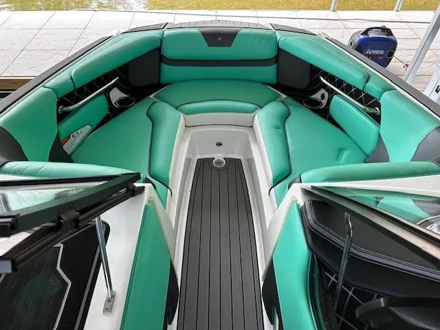 Slide: The Image of 2021 Nautique GS20 boat interior with teal and black seating. - 6