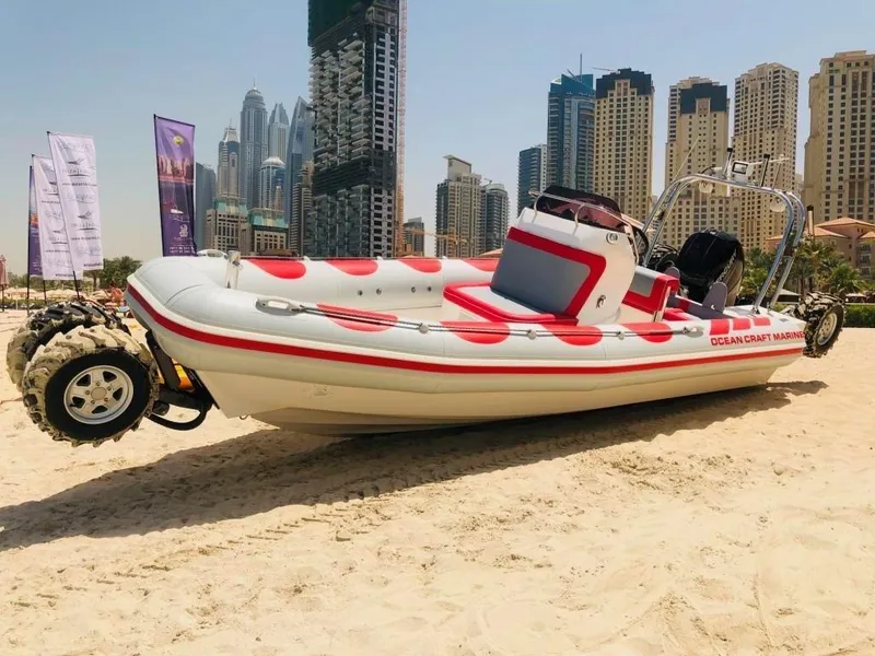 Slide: The Image of 2022 Ocean Craft Marine 7.1 M Amphibious boat on sandy beach with city skyline. - 7