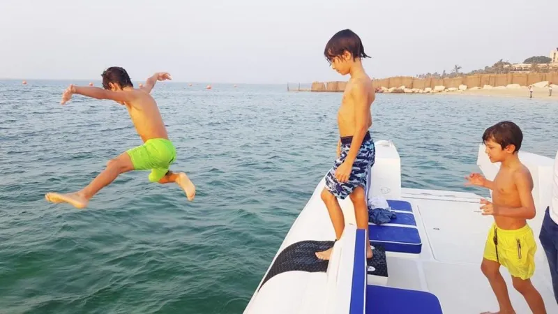 Slide: The Image of Children jumping off Ocean Craft Marine Beachlander 8.75 boat into the sea, 2022 model. - 28