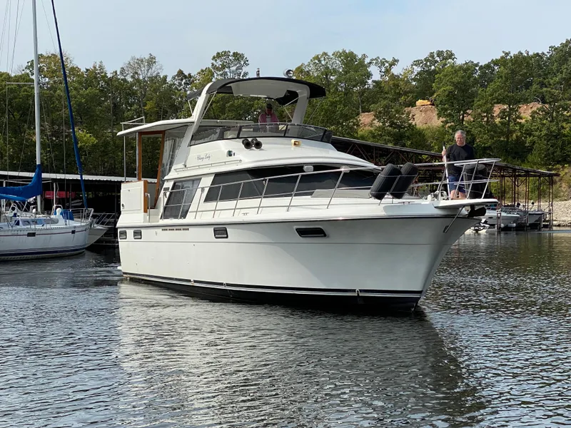 Slide: The Image of 1986 Carver 4207MY yacht cruising on a lake with trees in the background. - 15