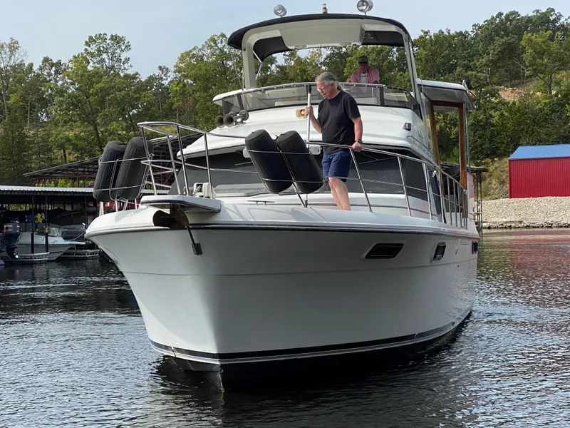 Slide: The Image of 1986 Carver 4207MY yacht cruising on a lake with people on board. - 19