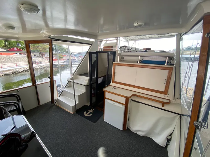 Slide: The Image of Interior of 1986 Carver 4207MY yacht with stairs, mini fridge, and marina view. - 33