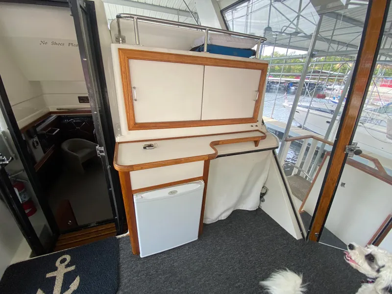 Slide: The Image of 1986 Carver 4207MY yacht interior with mini fridge and storage cabinets. - 36