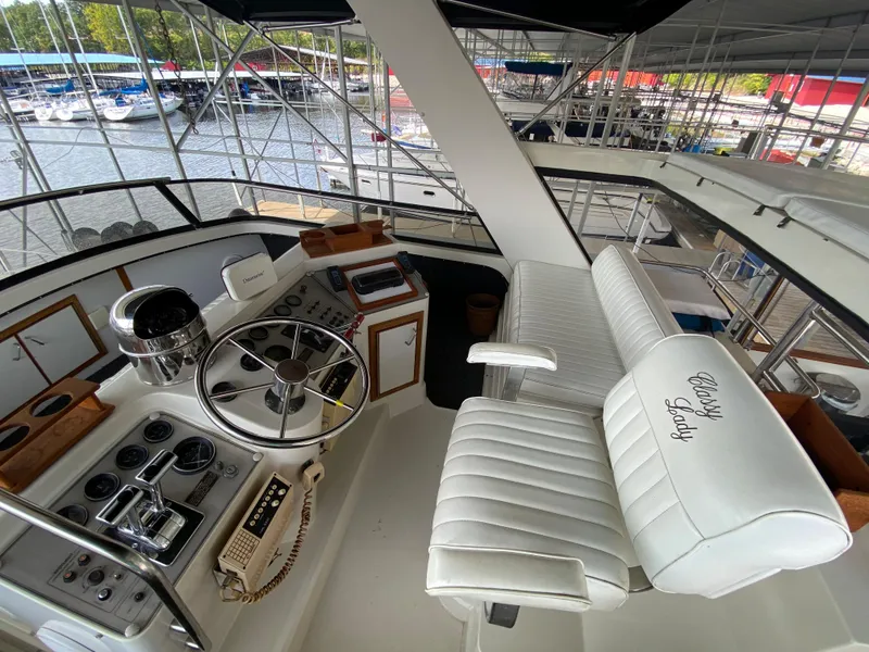 Slide: The Image of Captain's helm of a 1986 Carver 4207MY yacht with white leather seats. - 46