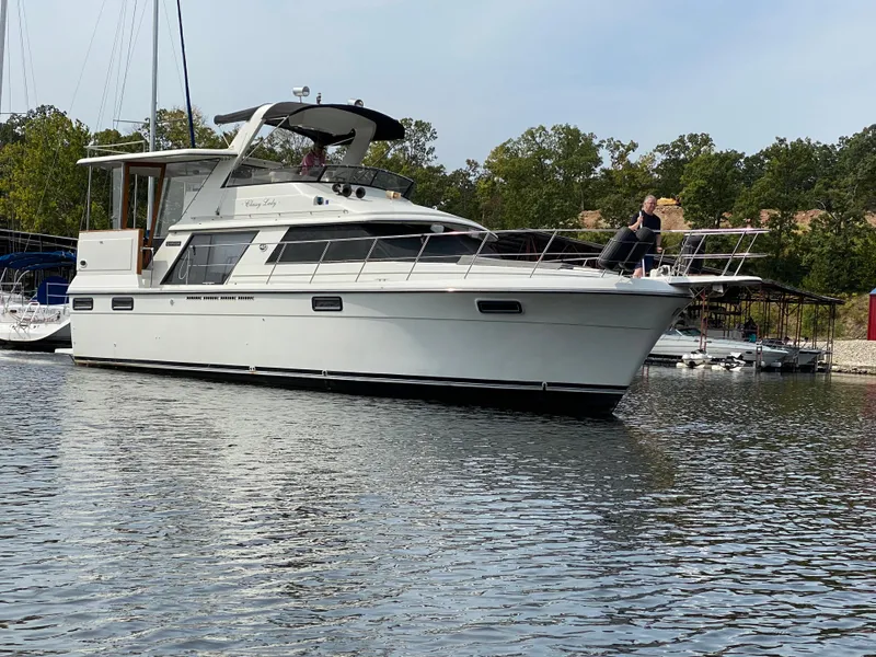 Slide: The Image of 1986 Carver 4207MY yacht on calm water with trees in the background. - 14