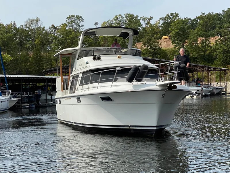 Slide: The Image of 1986 Carver 4207MY yacht cruising on a lake near a marina. - 16