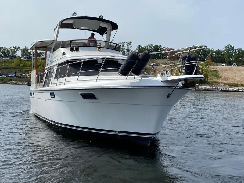 The Image of 1986 Carver 4207MY yacht cruising on a calm river. - 2