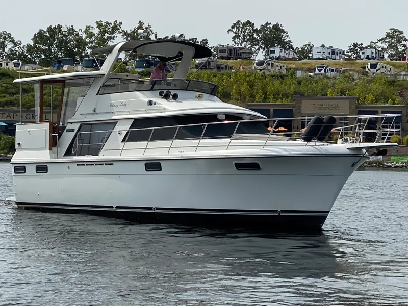 Slide: The Image of 1986 Carver 4207MY yacht cruising on a calm waterway. - 22