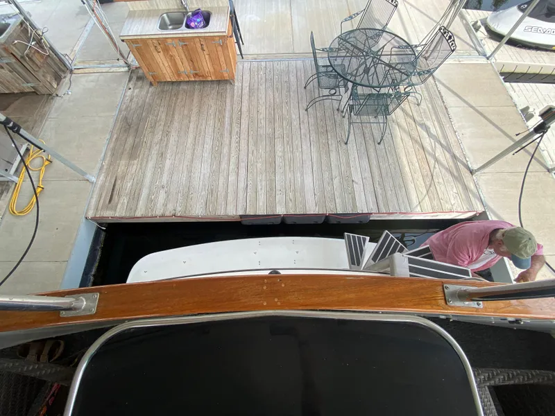 Slide: The Image of View from 1986 Carver 4207MY yacht showing dock, outdoor furniture, and a person boarding. - 35