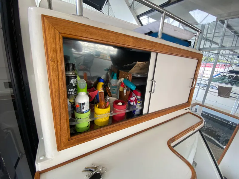 Slide: The Image of Storage cabinet on 1986 Carver 4207MY boat with cleaning supplies and keys. - 39