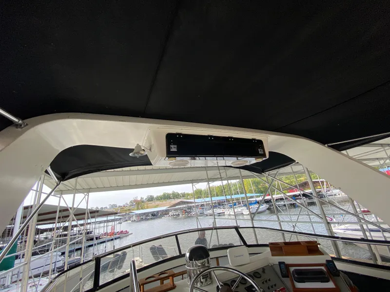 Slide: The Image of 1986 Carver 4207MY yacht interior helm station with marina view. - 42