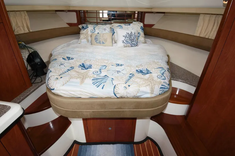 Slide: The Image of 2009 Monterey 340 Sport Yacht cabin with a cozy bed and nautical-themed bedding. - 14