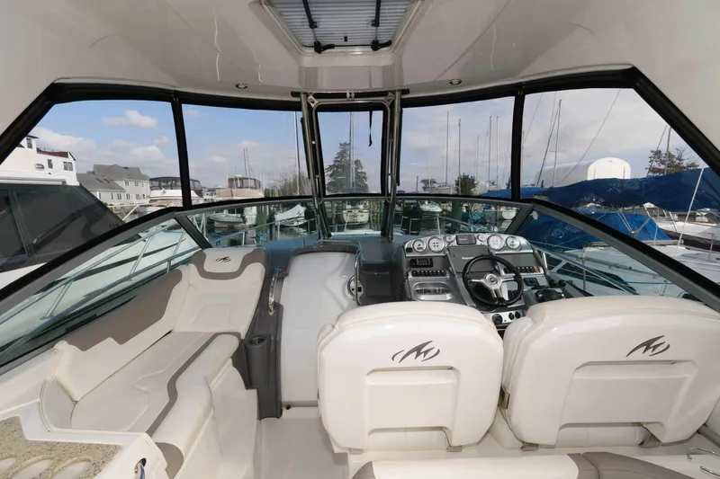 Slide: The Image of 2009 Monterey 340 Sport Yacht cockpit with helm, seating, and panoramic windows. - 5