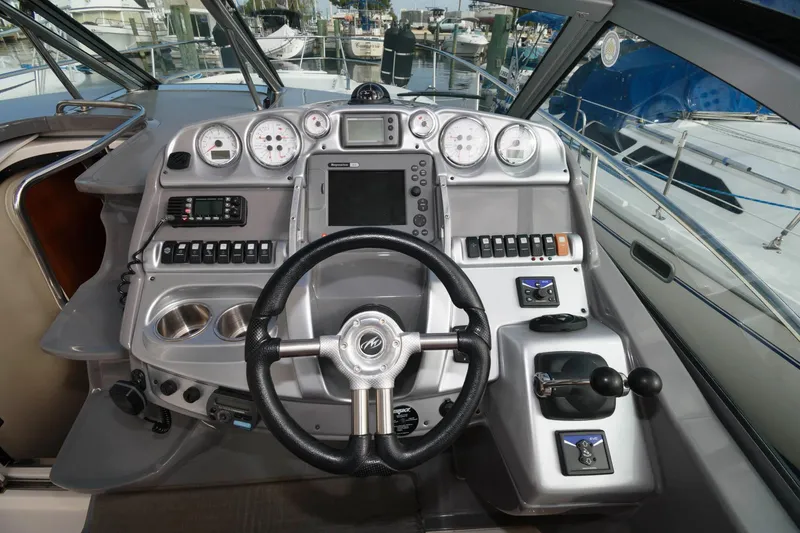 Slide: The Image of 2009 Monterey 340 Sport Yacht helm with steering wheel, gauges, and navigation controls. - 9