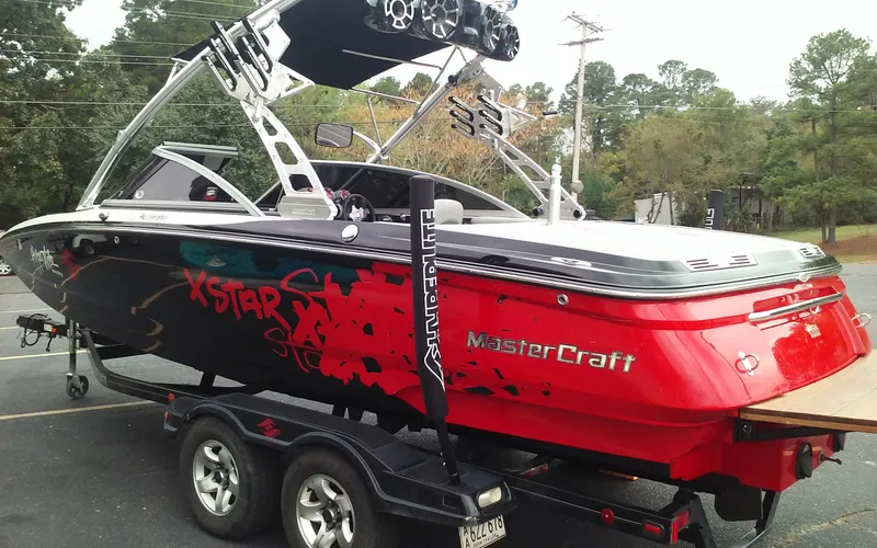 Slide: The Image of 2006 MasterCraft X-Star SS boat on trailer with vibrant red and black design. - 2