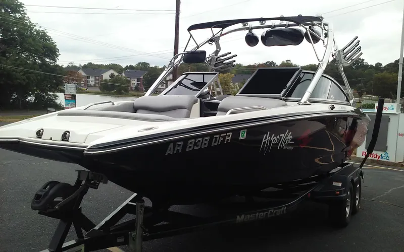 Slide: The Image of 2006 MasterCraft X-Star SS boat on trailer, black exterior, parked near a lake. - 7