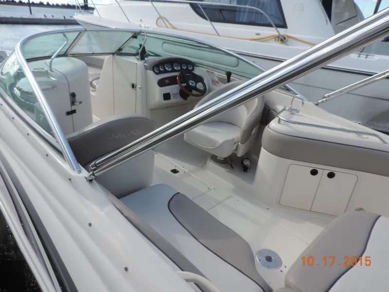 The Image of 2003 Sea Ray Bow Rider interior with seating and dashboard, docked near another boat. - 1