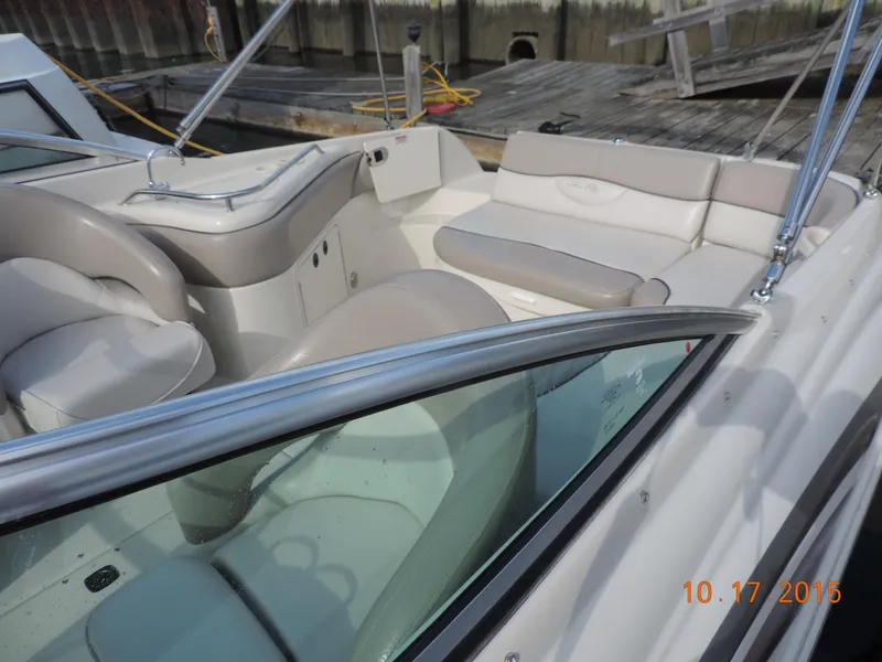 Slide: The Image of 2003 Sea Ray Bow Rider boat interior with beige seating and dock background. - 3