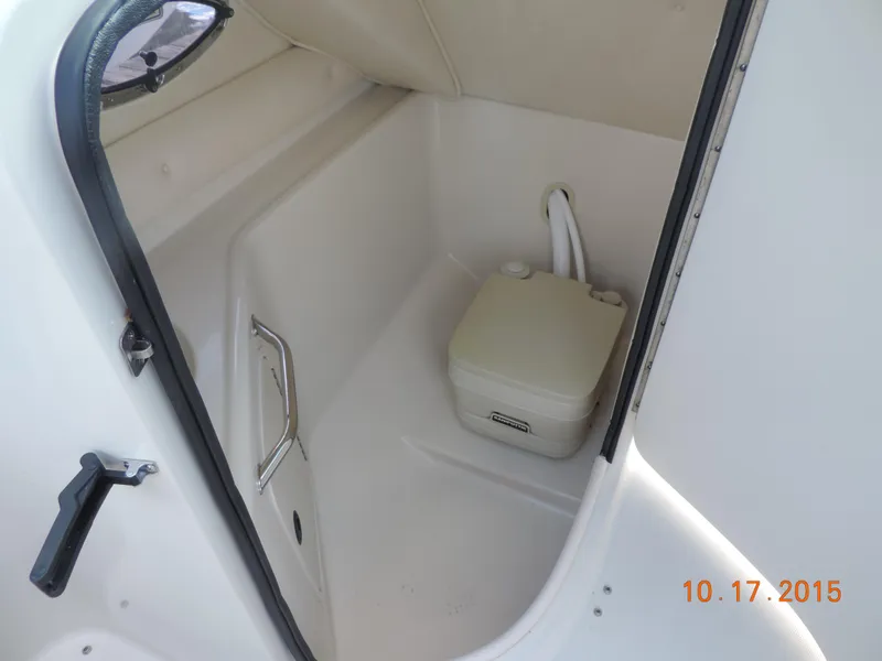 Slide: The Image of 2003 Sea Ray Bow Rider interior with portable toilet, white cabin space. - 4