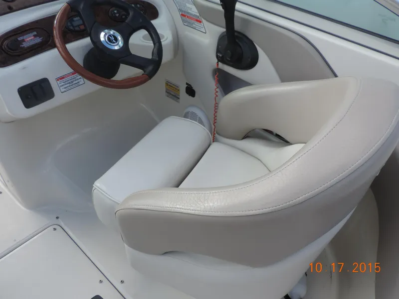Slide: The Image of 2003 Sea Ray Bow Rider cockpit with steering wheel and beige seating. - 9