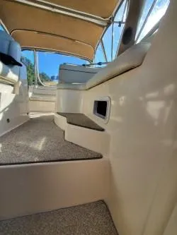 Slide: The Image of 2006 Rinker 300 Express Cruiser interior with seating and steps, featuring beige upholstery. - 10