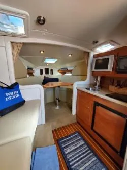 Slide: The Image of 2006 Rinker 300 Express Cruiser interior with kitchenette, seating, and skylights. - 12