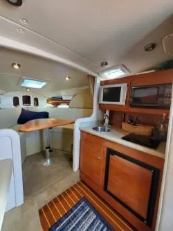 Slide: The Image of 2006 Rinker 300 Express Cruiser interior with kitchenette and seating area. - 13