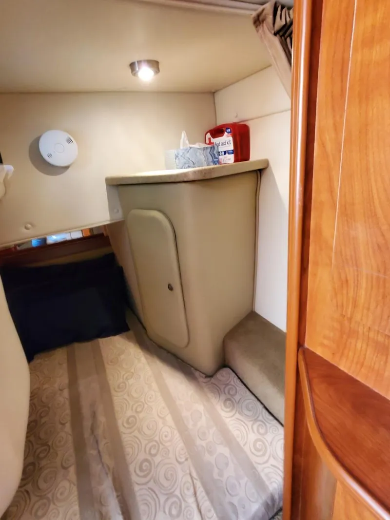 Slide: The Image of 2006 Rinker 300 Express Cruiser cabin interior with bed and storage. - 18