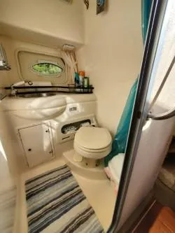 Slide: The Image of 2006 Rinker 300 Express Cruiser bathroom with sink, toilet, and striped rug. - 21